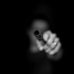 man holding gun in black screen