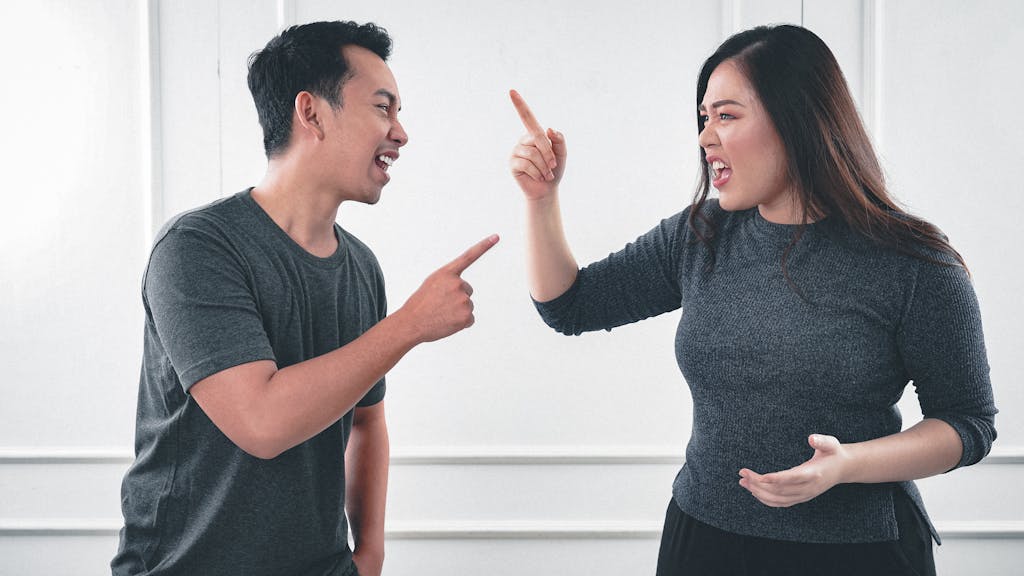 A Man and Woman Arguing while Pointing Fingers