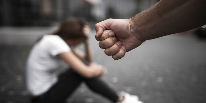 Man with tensed fist with a distraught Woman in the background Assault Charge